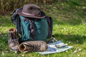 Rucksack mit Wanderschuhen, Karte und Kompass