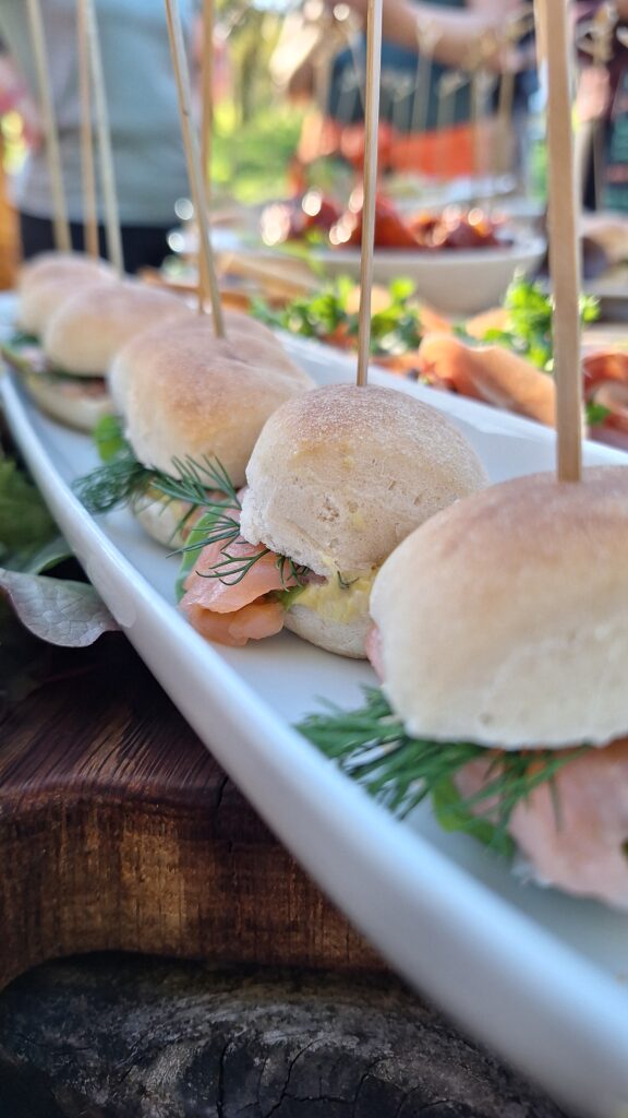 Nahaufnahme von mehreren Mini-Burgern mit Lachsbelag.