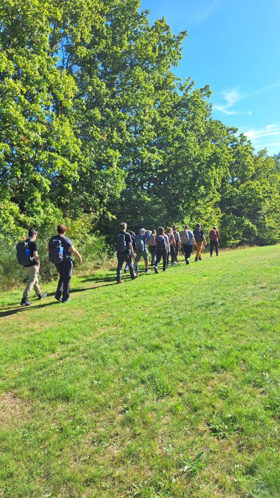 Eine Gruppe Wanderer läuft auf einer Wiese.